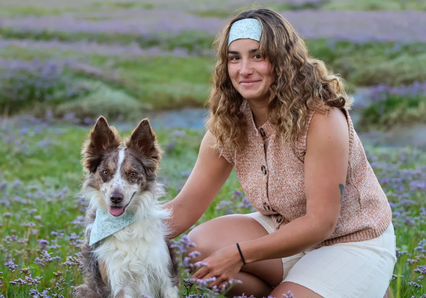 Femme et berger australien avec accessoires fleuris assortis dans un champ